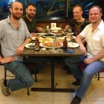 Matt, Luke, Russ and Phil smile mid-meal