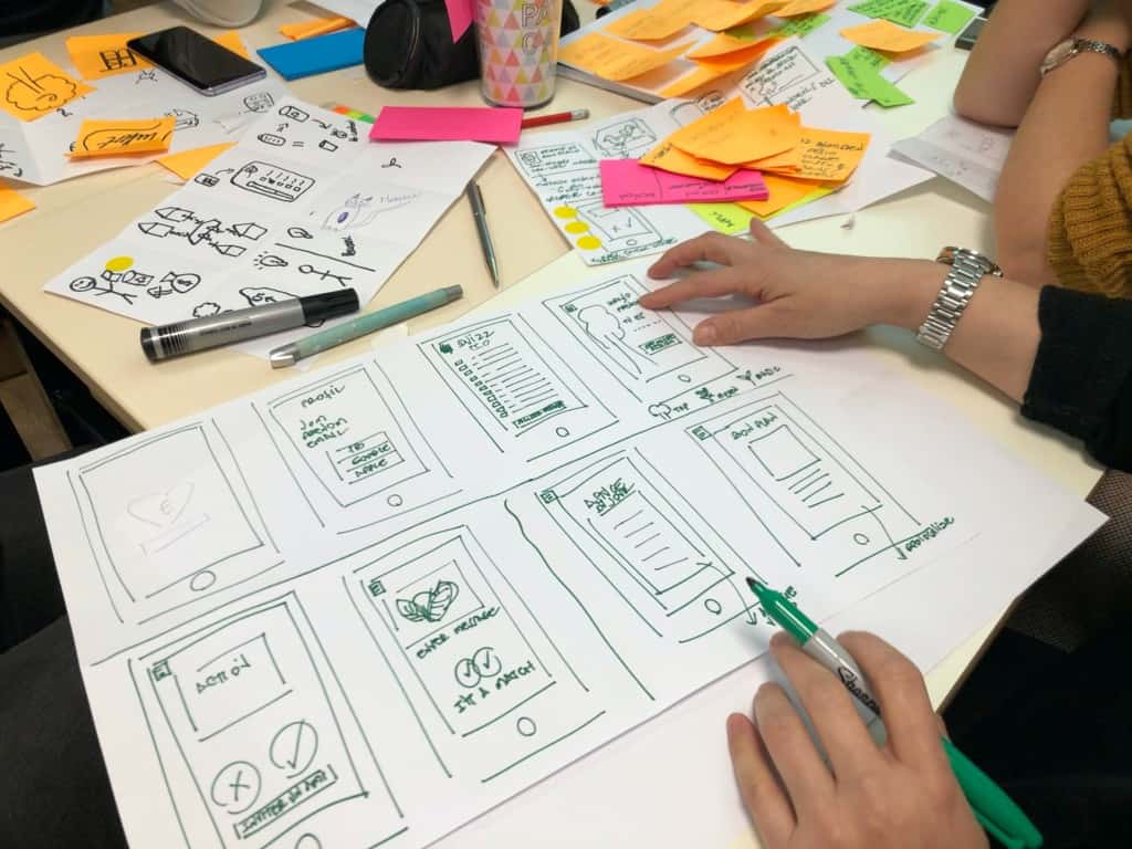 Person drawing wireframes on paper